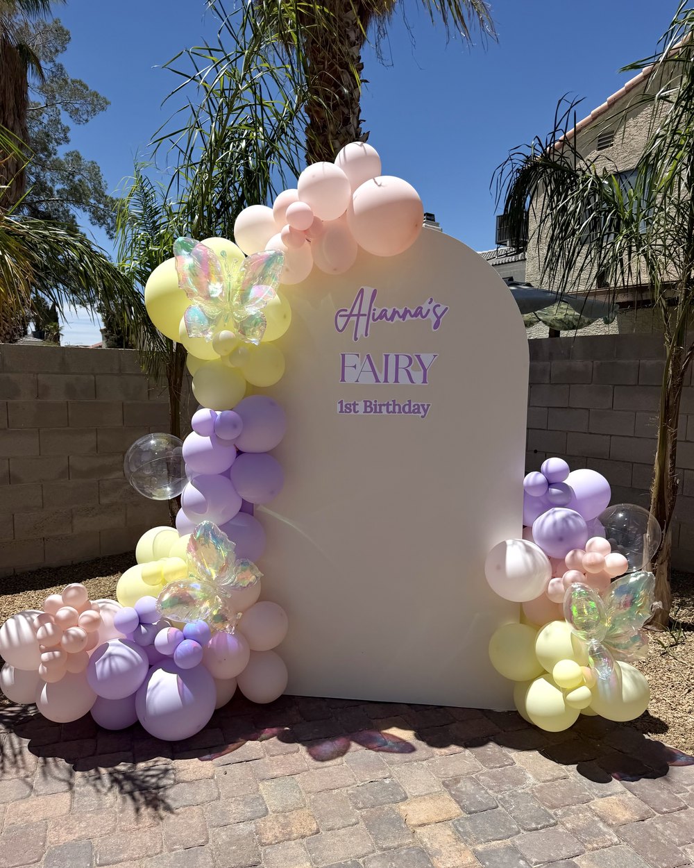Fairy first birthday arch in lavender, yellow and pink with iridescent butterfly balloons
